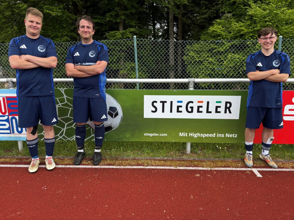 Die Spieler der Sportfreunde Dobel vor der neuen Werbebande unseres Internetpartners Stiegeler.